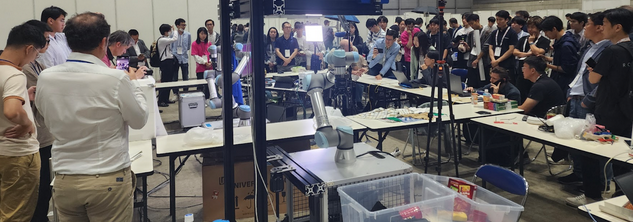 RGMC 9 at ICRA 2024: Audience and competition floor showing multiple team setups and demonstrations